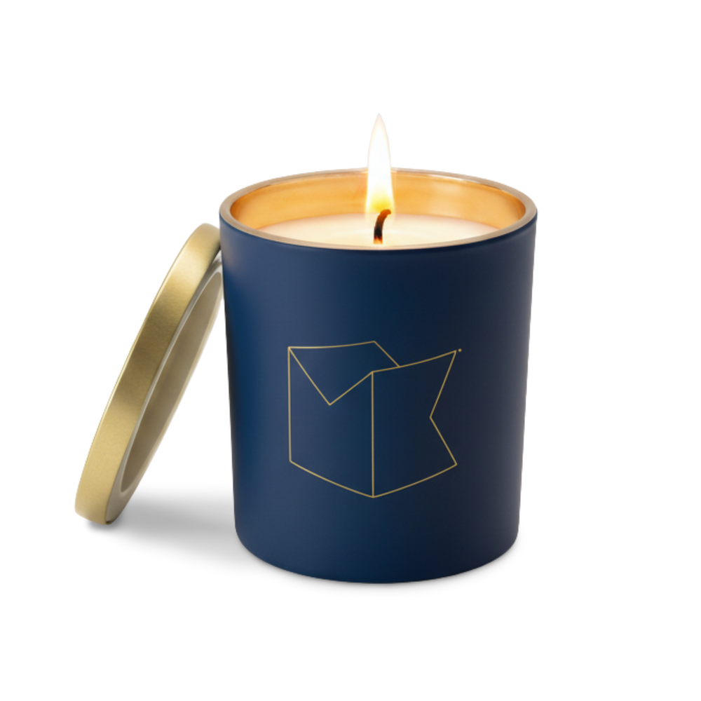 Blue Michael Knowles branded candle with gold lid on a white background