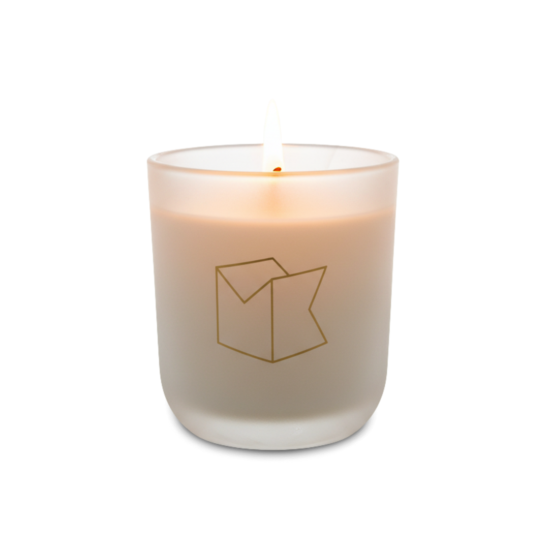 Candle in a glass container with a logo on a white background