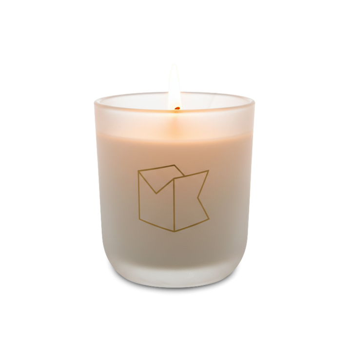 Candle in a glass container with a logo on a white background